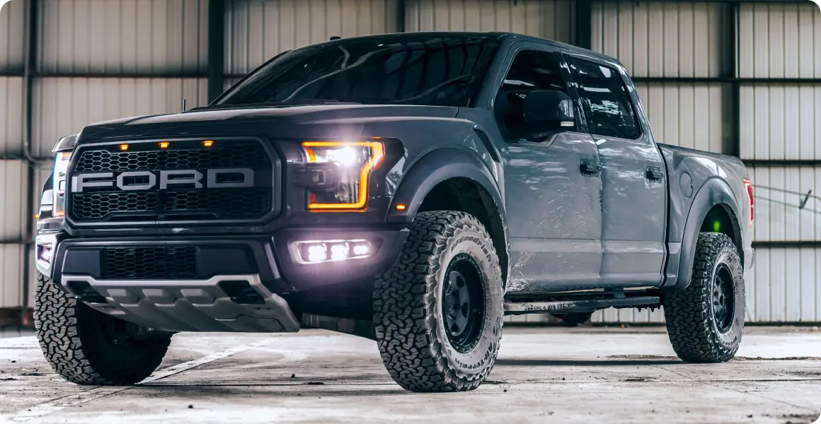 Black Ford truck in warehouse.