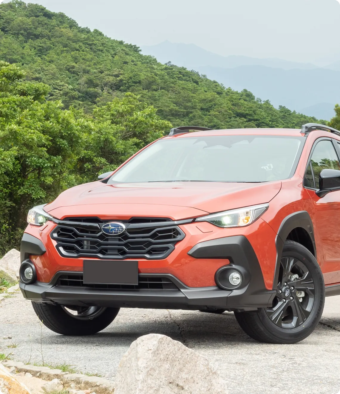 Orange Subaru SUV on rocky path