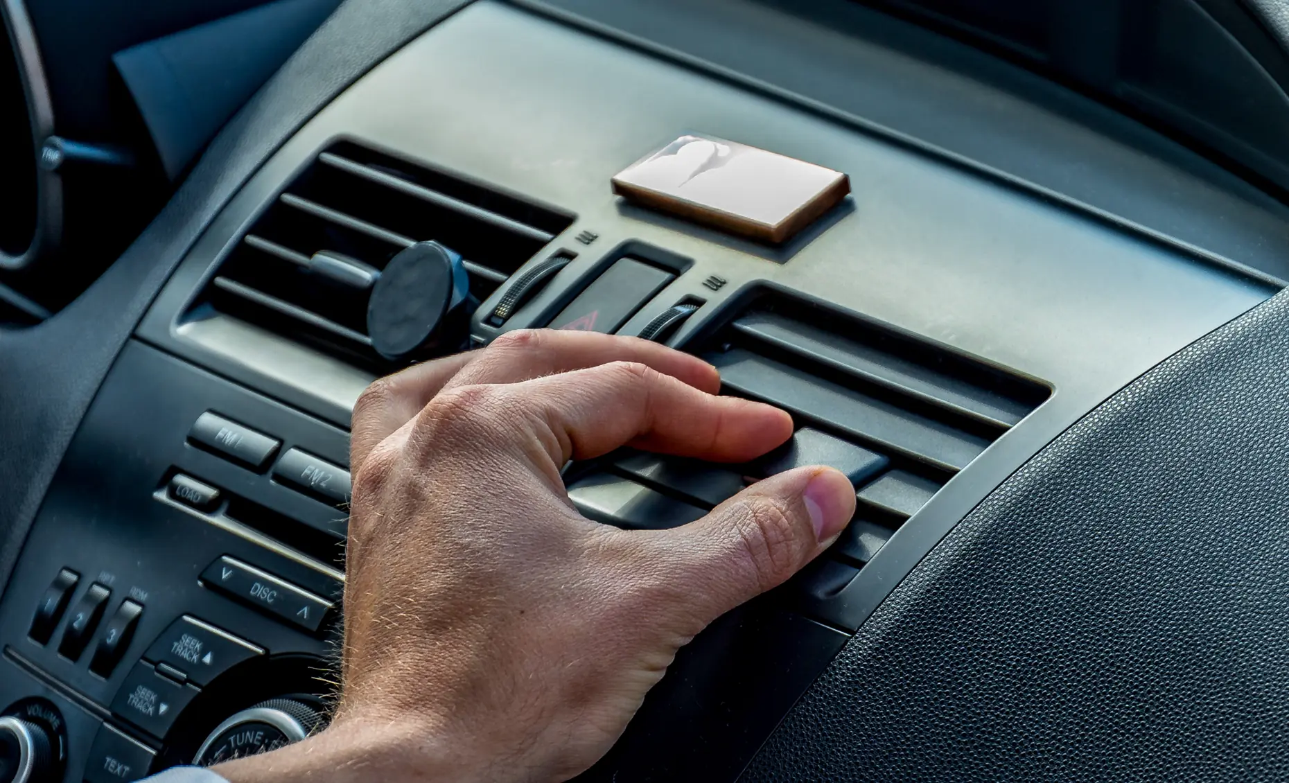 Auto a/c and heat repair in Albuquerque, NM by Albuquerque Auto Repair and Tire. Image of a driver adjusting air vents inside a vehicle, emphasizing comfort and reliable climate control.