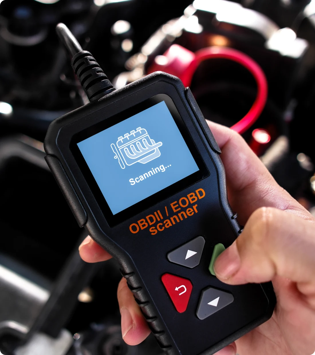 Handheld OBDII scanner in use.