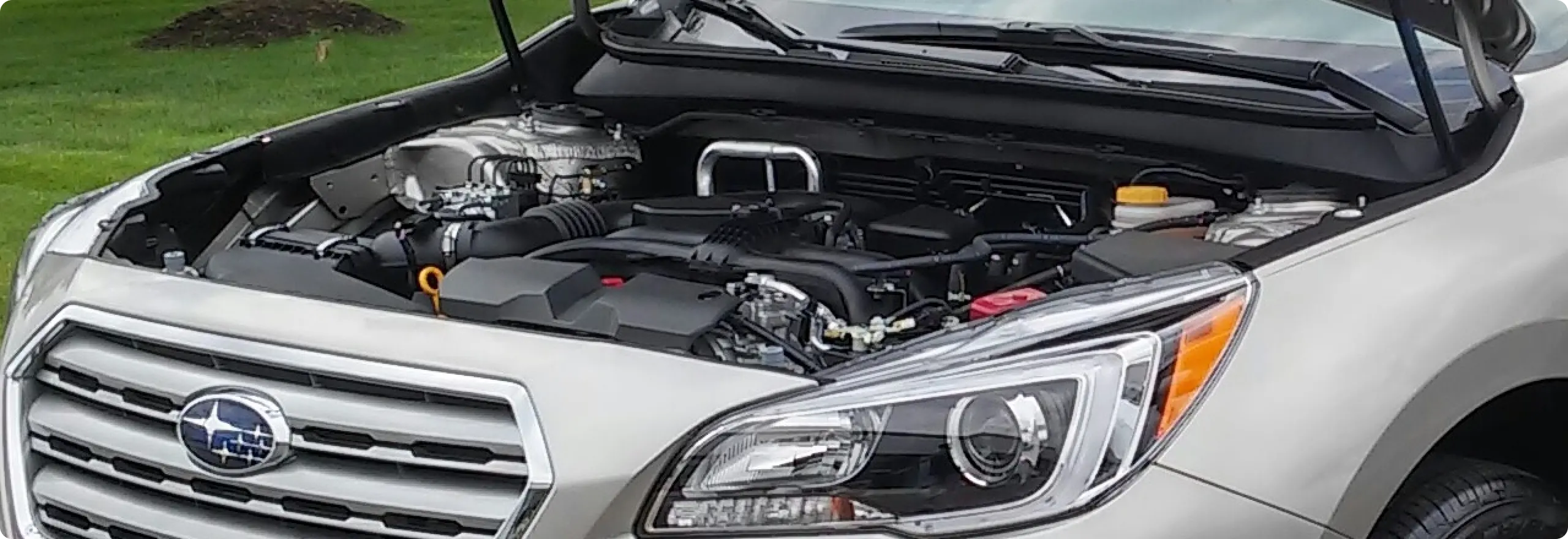 Car engine compartment with Subaru logo.