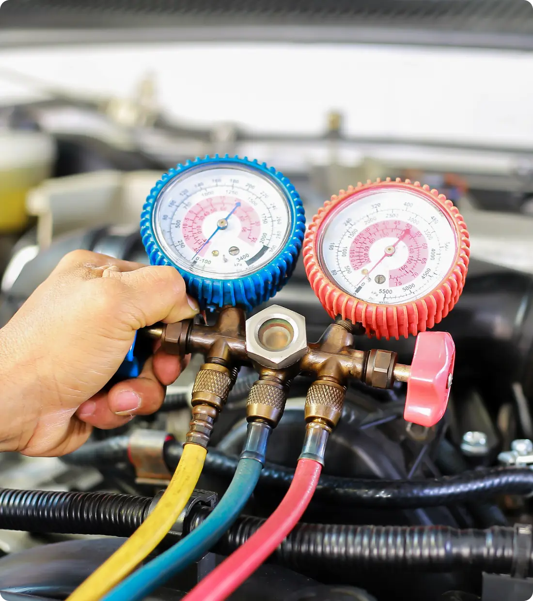 Man holding HVAC pressure gauges.
