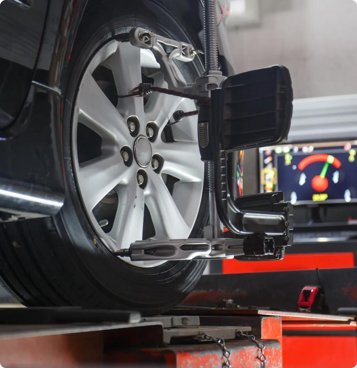 Car wheel alignment equipment in use.