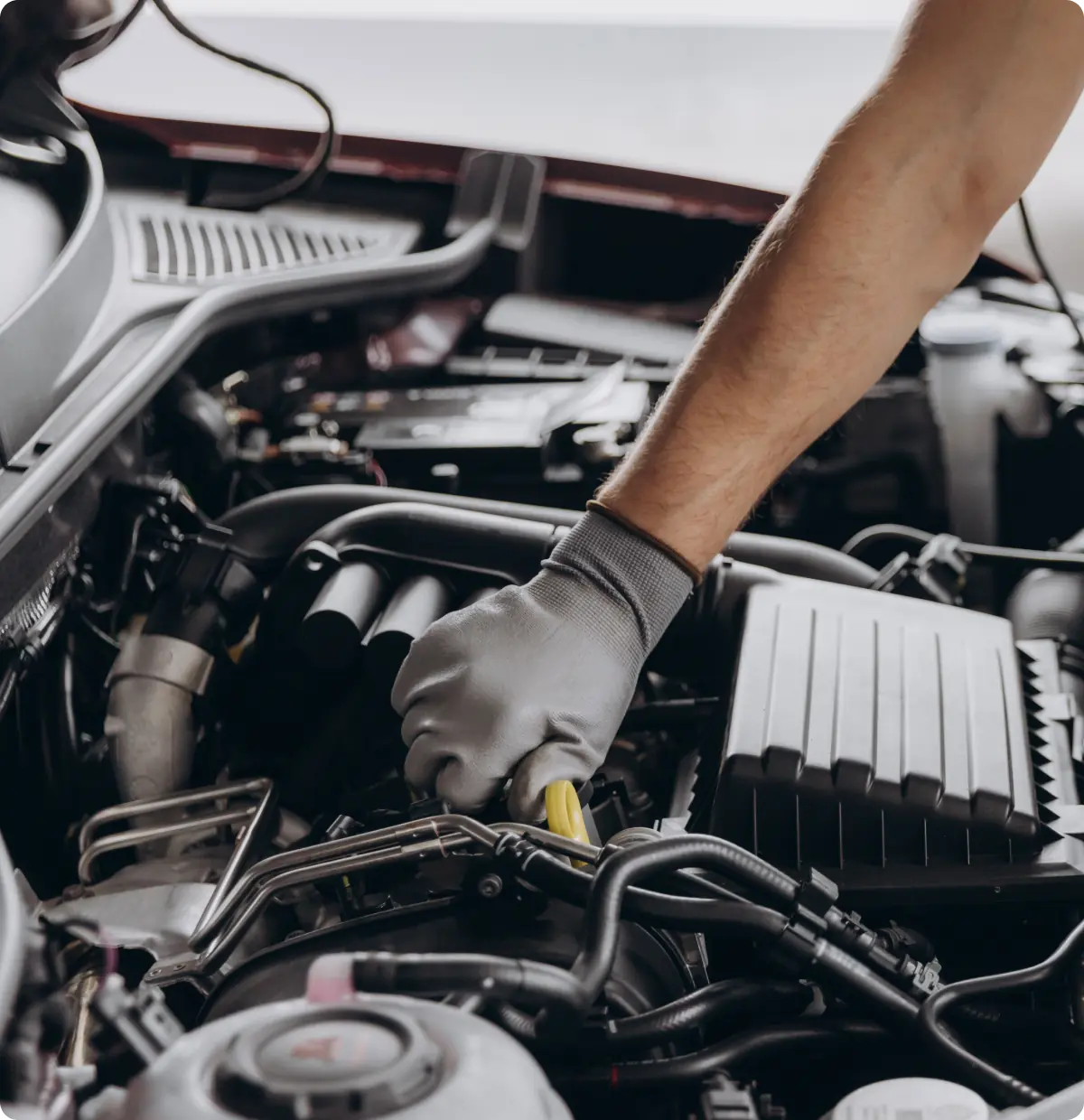 An image of a mechanic working on car engine.