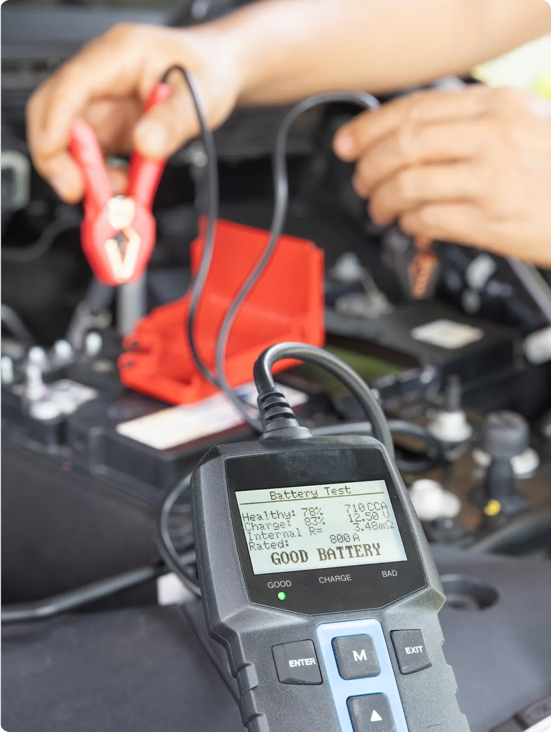 Testing car battery with multimeter.
