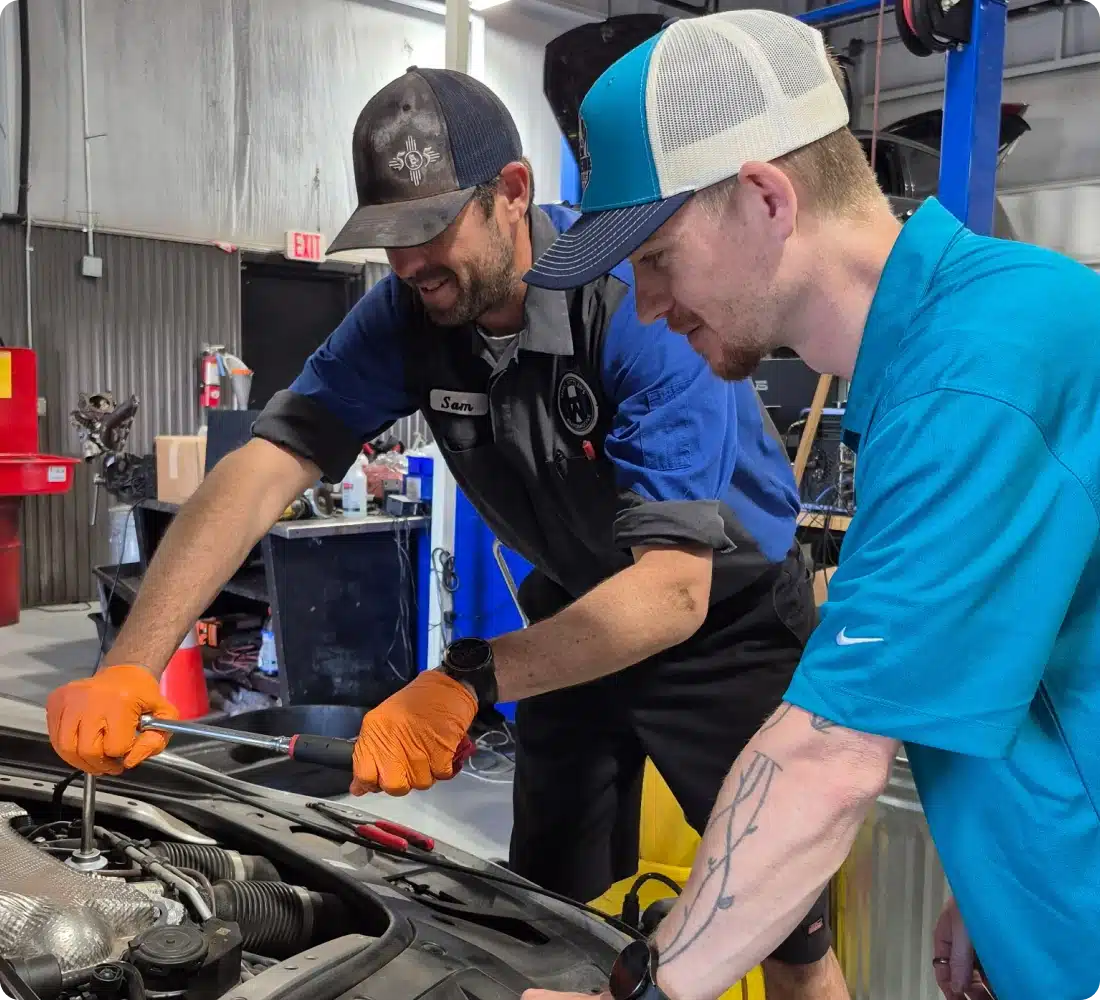 Two mechanics working on a car.